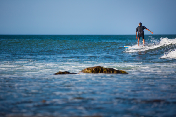 joven surfeando la ola en un
