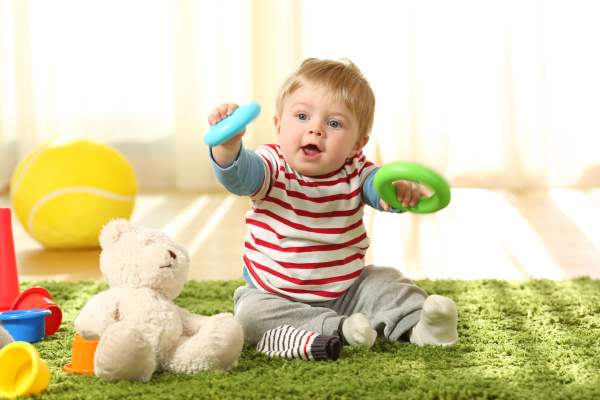 Un Niño Pequeño Y Feliz Está Jugando Con Juguetes Para Recién Nacidos Foto  de archivo - Imagen de tenencia, felicidad: 179772790