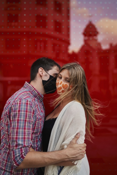 pareja besandose con mascarilla protectora contra